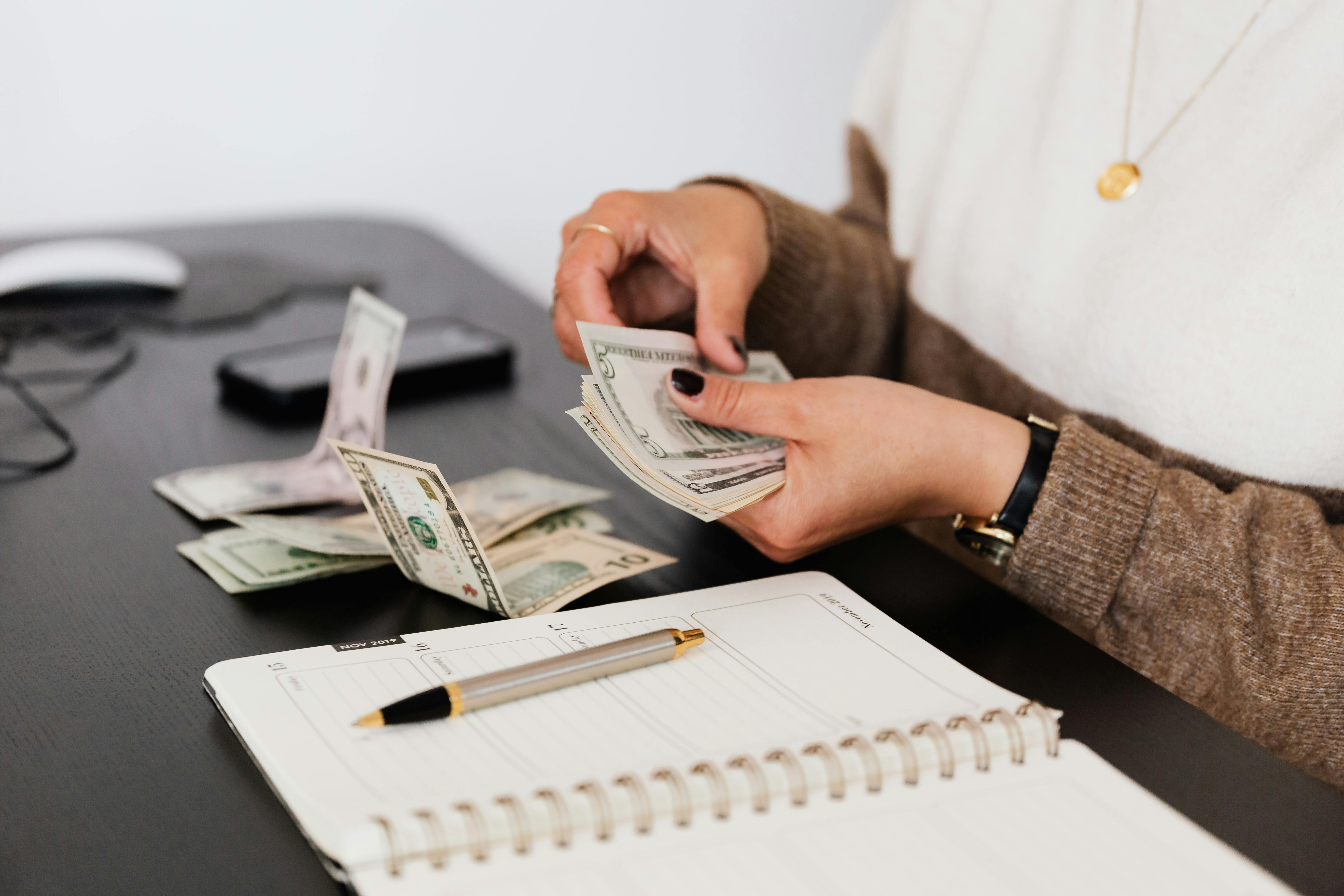 Photo of person counting money for their bills