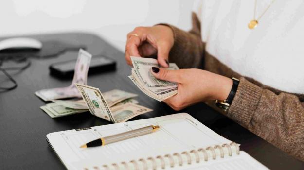 Photo of person counting money for their bills